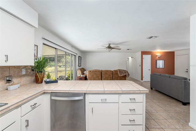 kitchen with ceiling fan, white cabinets, dishwasher, and tile countertops