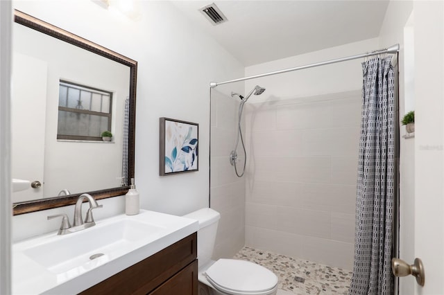 bathroom featuring curtained shower, toilet, and vanity