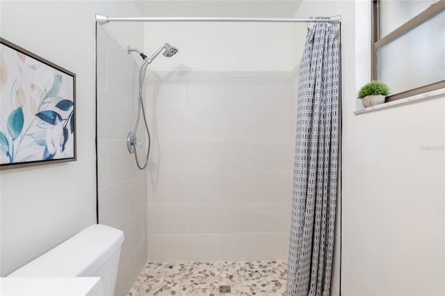 bathroom featuring toilet and curtained shower