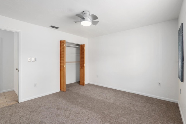 unfurnished bedroom featuring ceiling fan, light colored carpet, and a closet