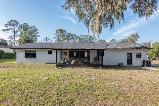 rear view of house featuring a sunroom and a lawn