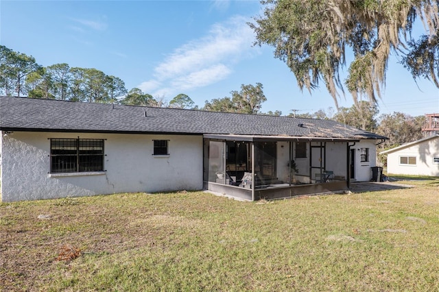 back of property featuring a lawn and a sunroom