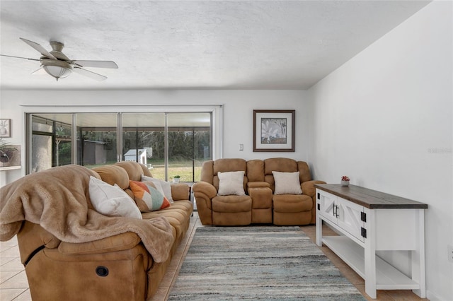 tiled living room with ceiling fan and a textured ceiling