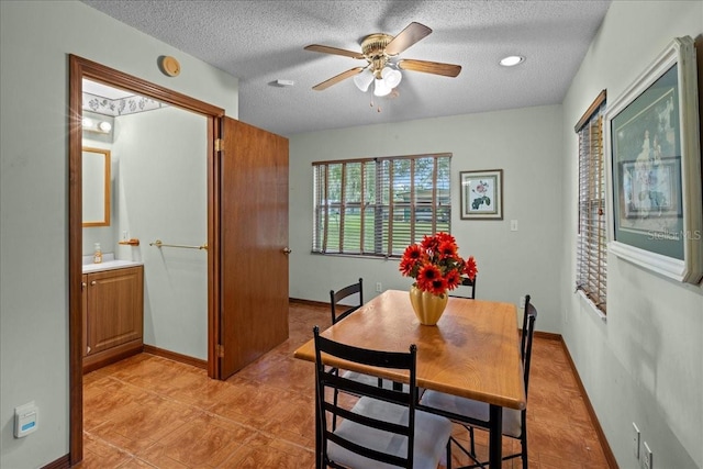 dining area featuring ceiling fan, light tile patterned floors, and a textured ceiling