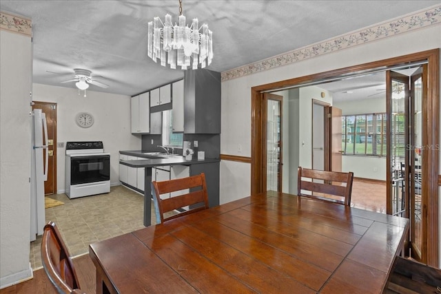 dining room with a textured ceiling, sink, and ceiling fan with notable chandelier