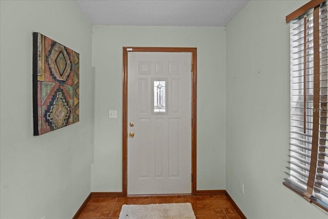 foyer entrance featuring tile patterned floors and a textured ceiling