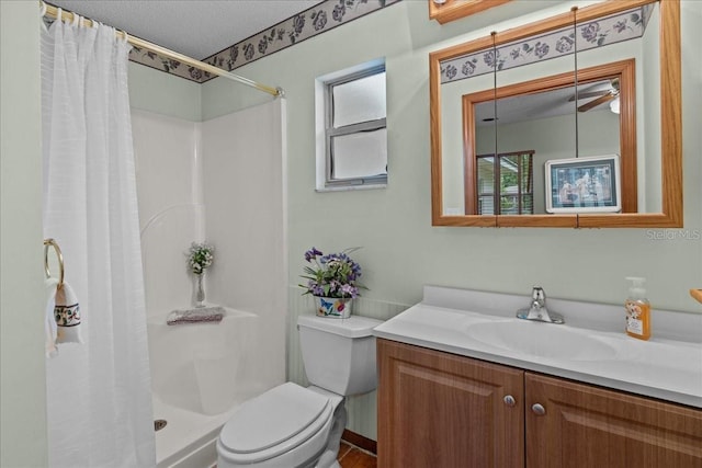 bathroom featuring a shower with shower curtain, vanity, a textured ceiling, ceiling fan, and toilet