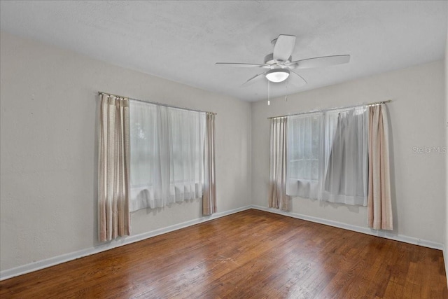 spare room with hardwood / wood-style flooring and ceiling fan