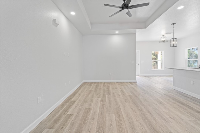 empty room featuring a textured ceiling, light hardwood / wood-style flooring, and ceiling fan