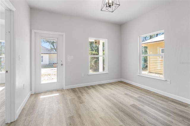 interior space with light wood-type flooring and a notable chandelier