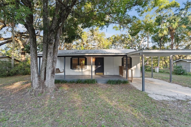 view of front facade with a carport, a porch, and a front yard