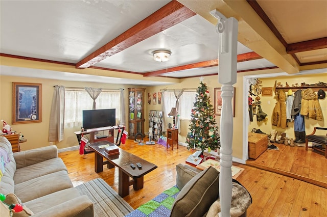 living room with beamed ceiling, plenty of natural light, and light wood-type flooring