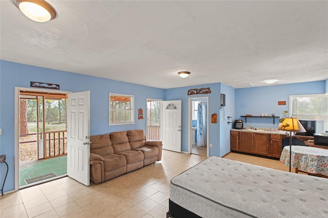 tiled bedroom featuring multiple windows and access to exterior