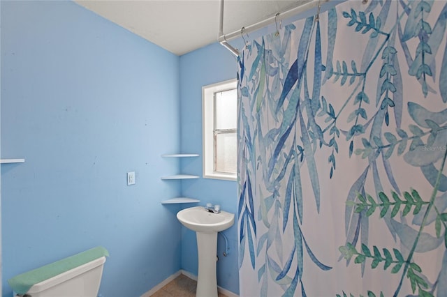 bathroom with sink, a shower with curtain, and toilet