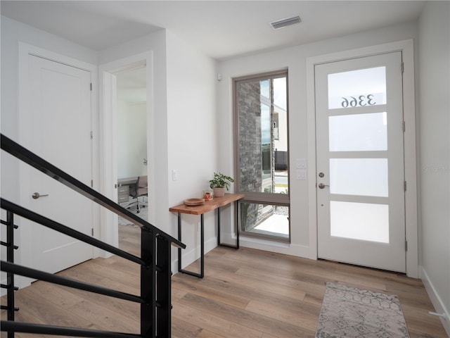 doorway to outside with a healthy amount of sunlight and light hardwood / wood-style floors