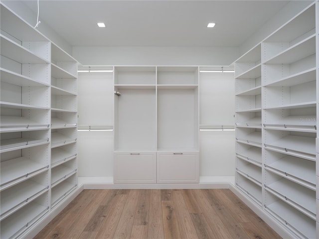 walk in closet with light hardwood / wood-style flooring