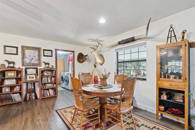 dining area featuring washing machine and dryer, wood-type flooring, and a textured ceiling