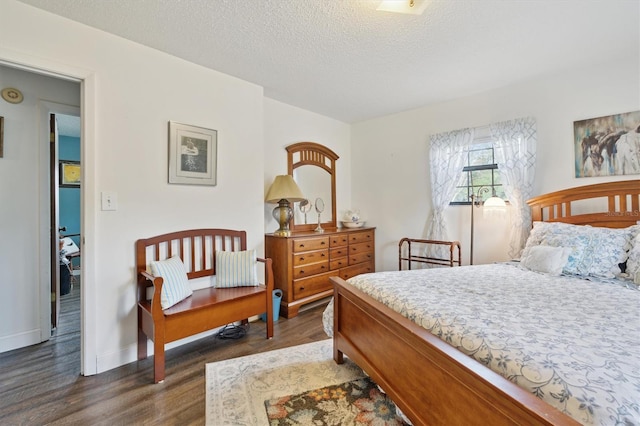 bedroom featuring a textured ceiling and dark hardwood / wood-style flooring