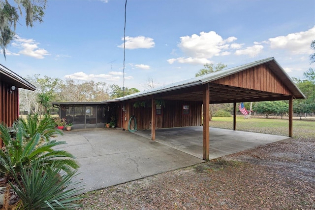 view of parking / parking lot featuring a yard and a carport