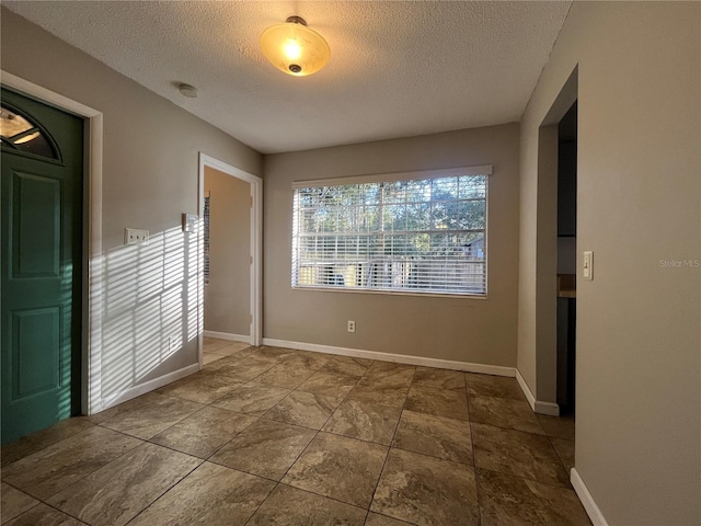 unfurnished room with a textured ceiling