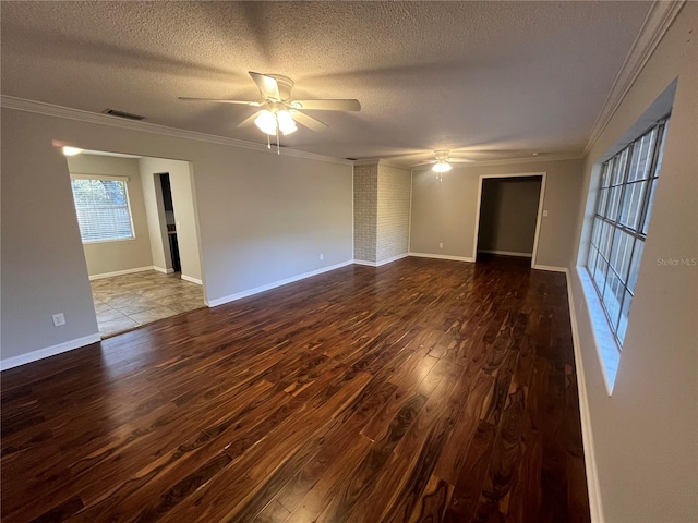 empty room featuring ceiling fan, dark wood-type flooring, a textured ceiling, and ornamental molding