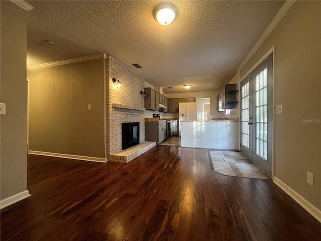 unfurnished living room with french doors, dark hardwood / wood-style flooring, a textured ceiling, and ornamental molding