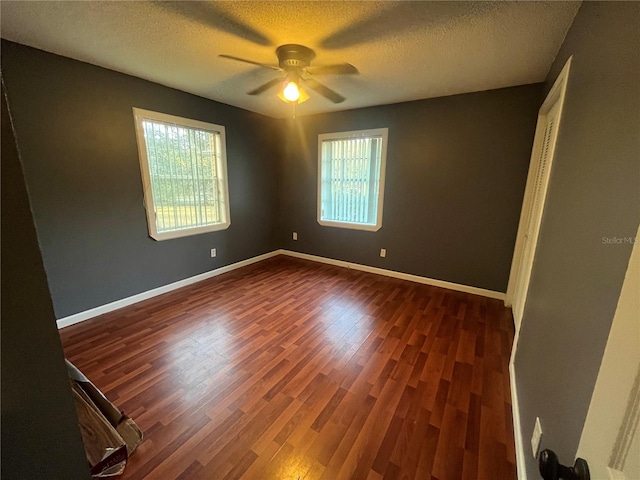 unfurnished room featuring a textured ceiling, ceiling fan, and dark wood-type flooring