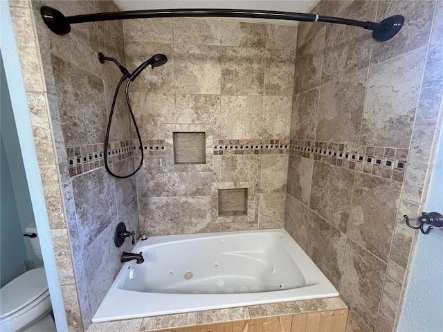 bathroom featuring tiled shower / bath combo and toilet