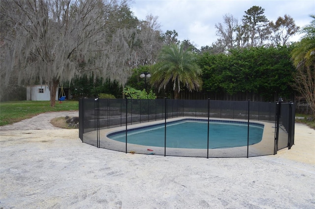 view of pool featuring a patio and a shed