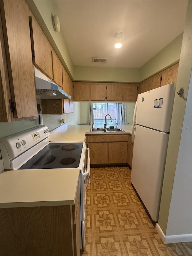 kitchen with kitchen peninsula, white appliances, and sink