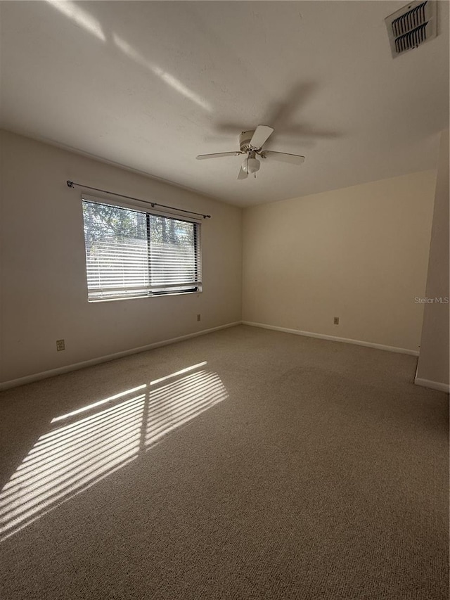 carpeted spare room with ceiling fan