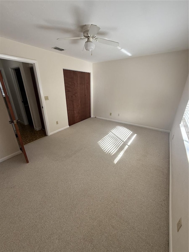 unfurnished bedroom with carpet, ceiling fan, and a closet