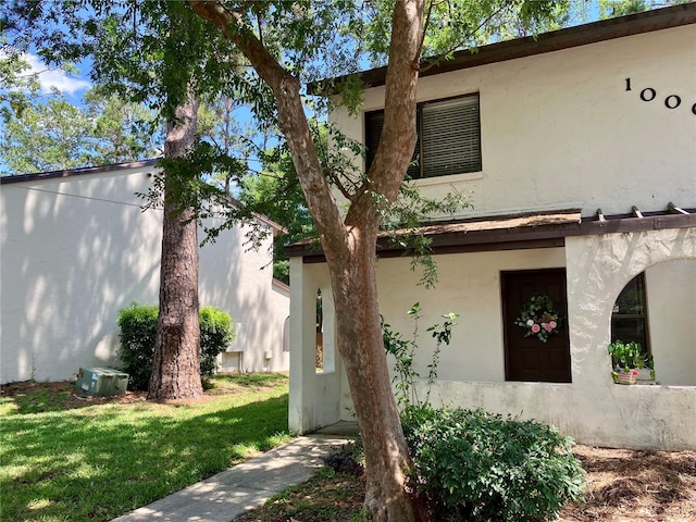 2635 SW 35th Pl Unit 1001, Gainesville, FL 32608 - view of property exterior with stucco siding and a lawn