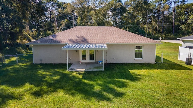 back of property with a lawn, french doors, and a patio