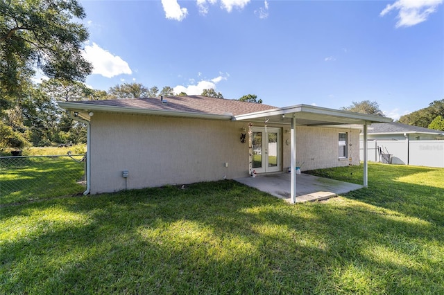 back of property with a lawn, a patio, and french doors