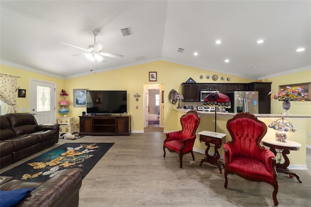 living room with crown molding, ceiling fan, lofted ceiling, and light wood-type flooring