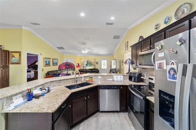 kitchen featuring stainless steel appliances, vaulted ceiling, light hardwood / wood-style floors, and sink