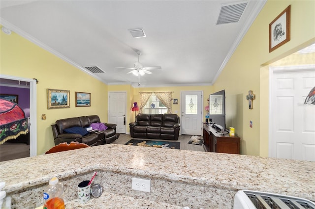 kitchen featuring ornamental molding, light stone counters, ceiling fan, and lofted ceiling