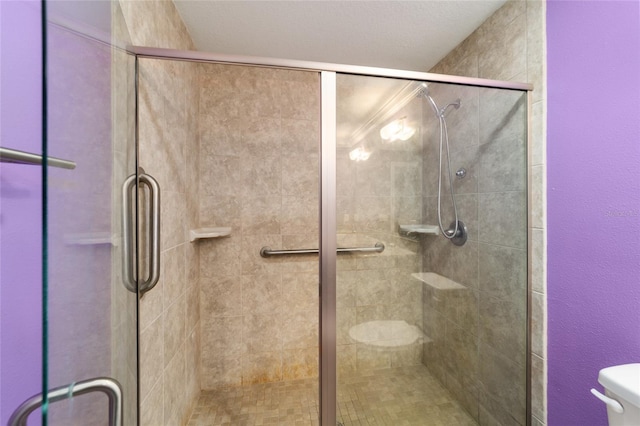 bathroom with toilet and a shower with shower door