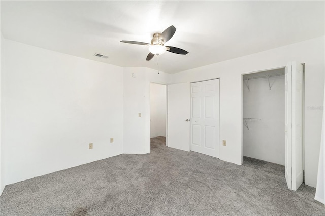 unfurnished bedroom featuring a ceiling fan, visible vents, and carpet flooring