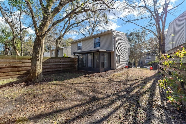 back of property featuring fence and a sunroom