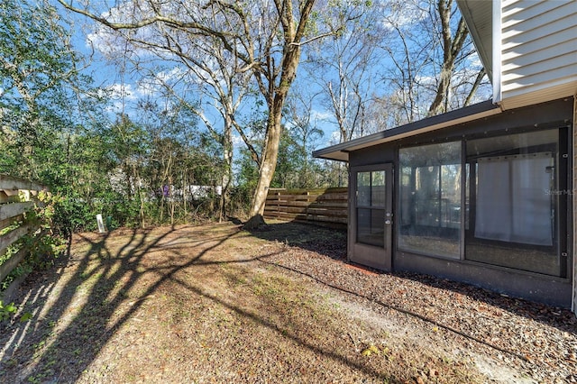 view of yard featuring a fenced backyard and a sunroom