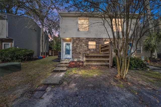 view of front facade with brick siding and a front yard