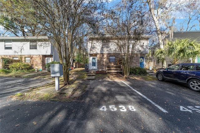 view of front of home featuring uncovered parking and brick siding