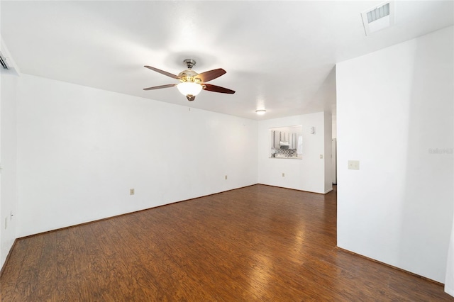 spare room featuring a ceiling fan, visible vents, and dark wood-style flooring