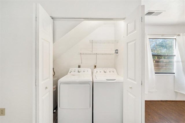 clothes washing area featuring laundry area, washing machine and dryer, visible vents, and wood finished floors