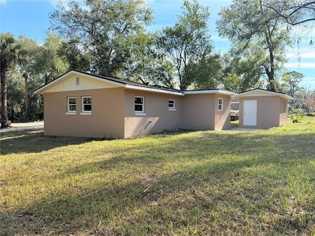 view of side of home featuring a shed and a lawn