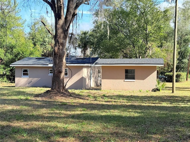 rear view of house featuring a lawn