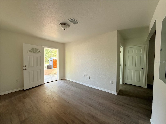 entryway with a textured ceiling and dark wood-type flooring