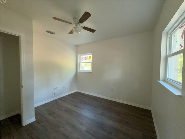 empty room with ceiling fan and dark hardwood / wood-style flooring